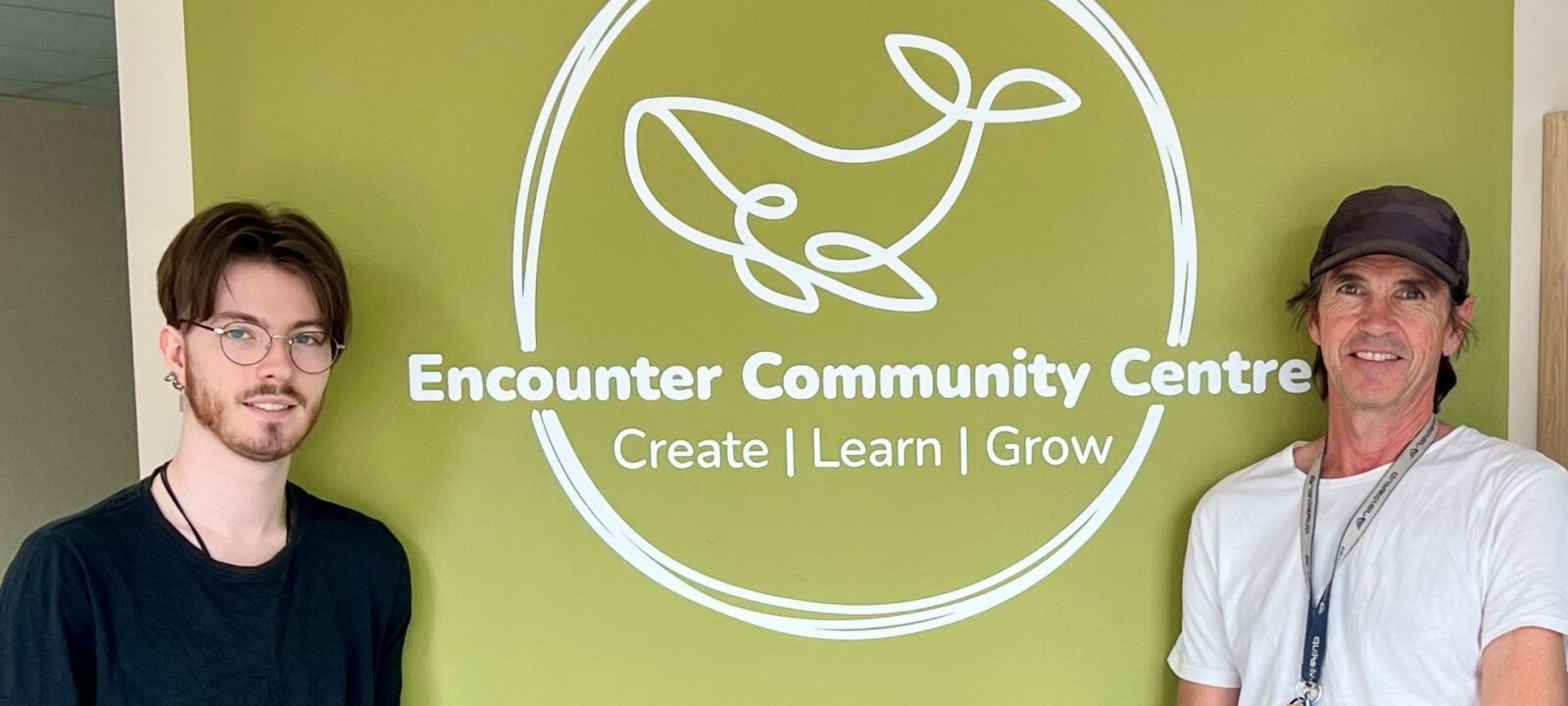 Two Jobseekers standing either side of the Encounter Community Centre sign.