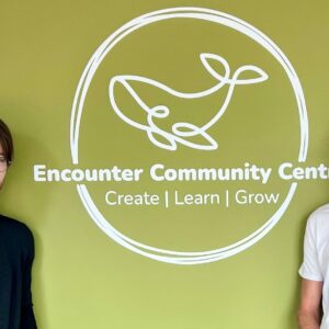 Two Jobseekers standing either side of the Encounter Community Centre sign.