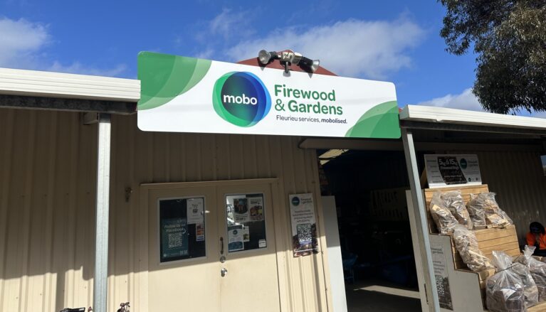 Sign on the front of a building that says mobo Firewood & Gardens, Fleurieu Services, mobolised.