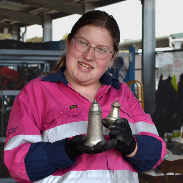 Employee in pink hi vis jacket holding vintage salt and pepper shakers,