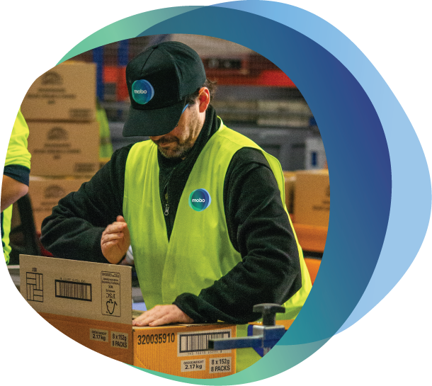Person with disability wearing hat and Hi Vis shirt closing and sealing cardboard box