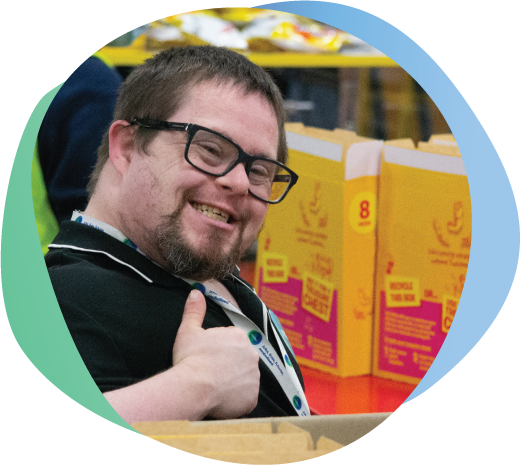 Employee wearing mobo shirt and lanyard giving thumbs up while packing boxes.